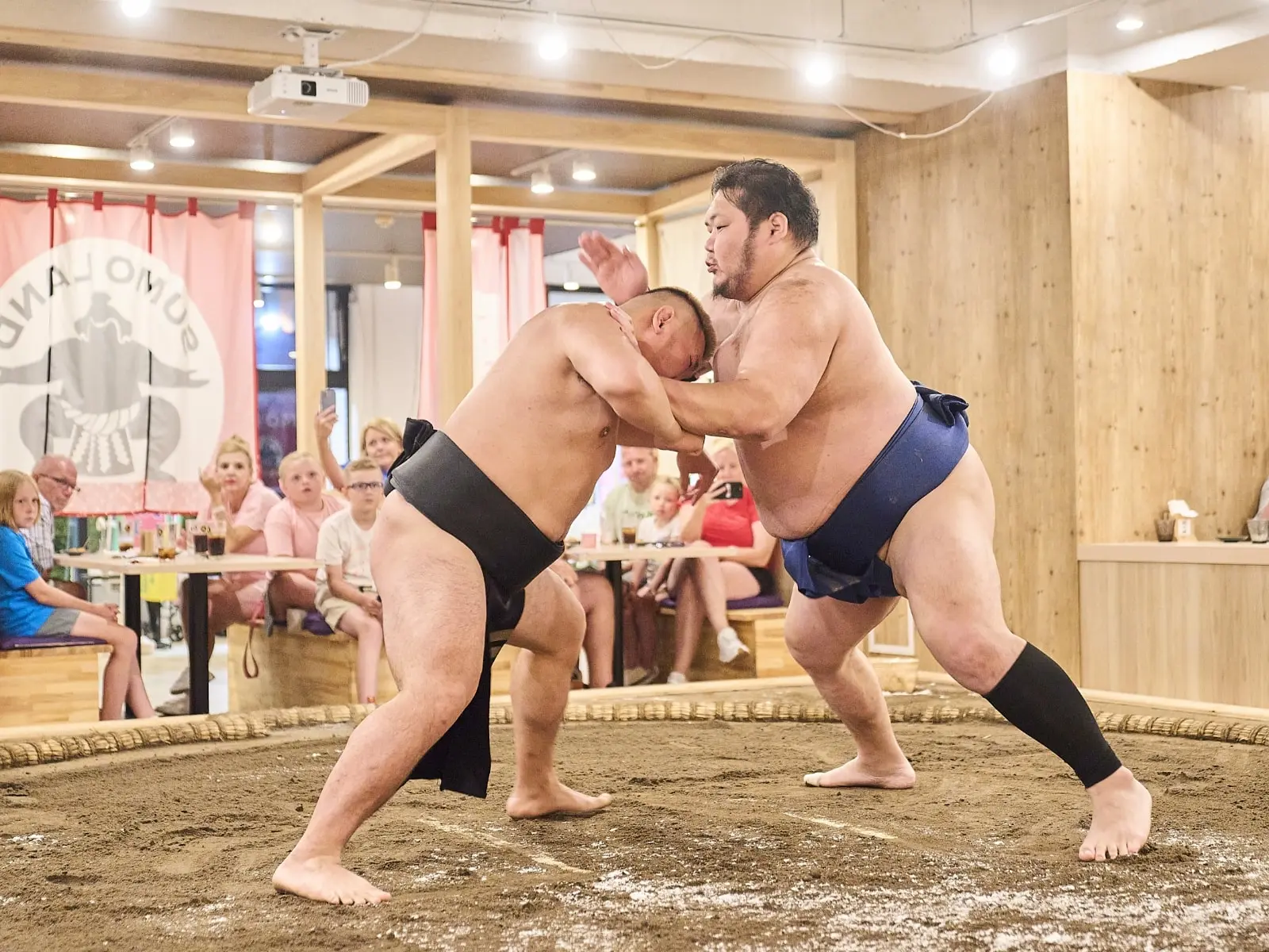 Sumo wrestlers competing in front of guests